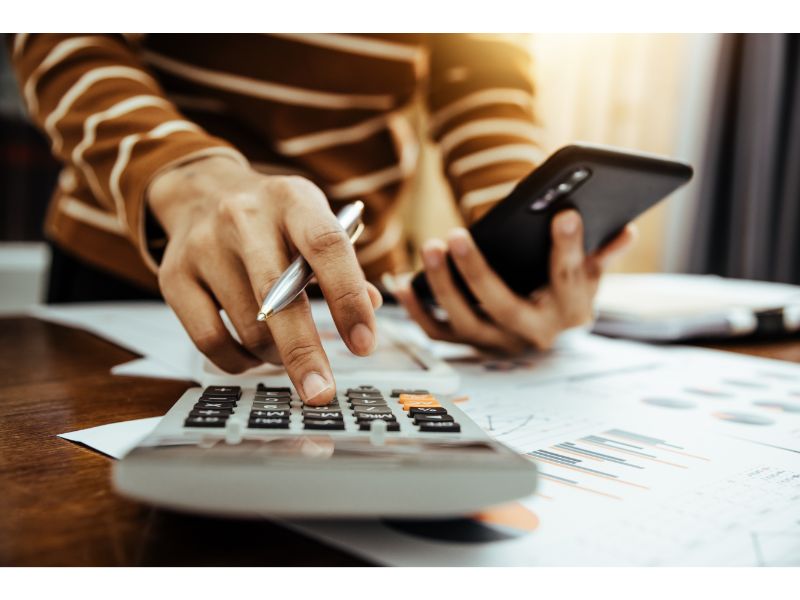 a property owner in austin calculating the costs of a concrete project using their phone and calculator